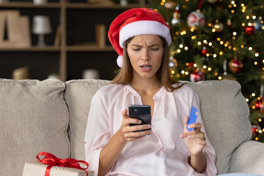 victim of holiday scams looks at phone